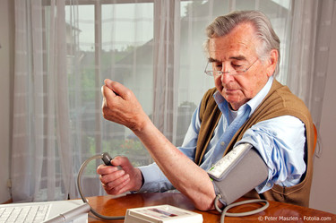 Ein älterer Mann misst seinen Blutdruck